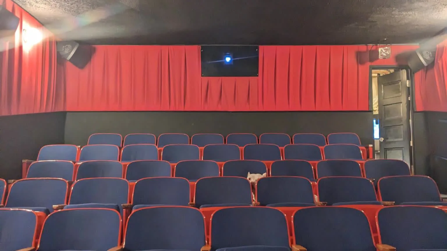 The Beacon's auditorium — rows of red and blue seats facing the curtained screen